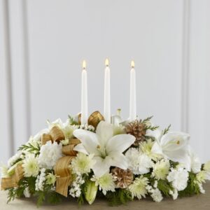 White Holiday Traditional Centerpiece Winter white flowers, evergreen accents, and golden ribbons & pinecones come together to create an elegant holiday candle-lit centerpiece. Send over your holiday wishes with white lilies and carnations. The White Holiday Traditional Centerpiece is great for celebrating any winter holiday such as Christmas and even New Year’s.
